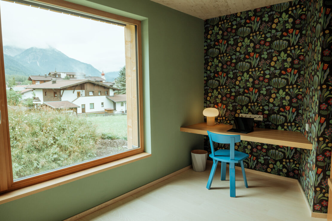 Workplace with a view of the mountains and floral wallpaper by Austrian architect and designer Josef Frank