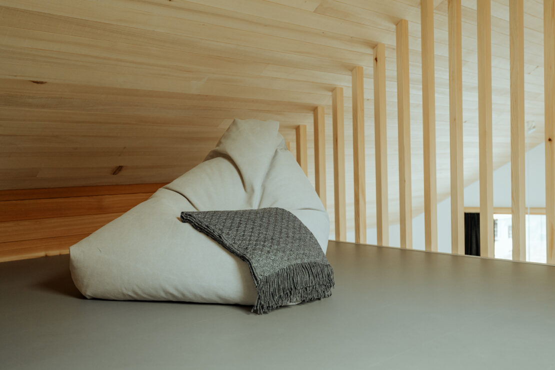 Grey sitting bag with blanket in a gallery in vaulted ceiling with exposed silver fir beams