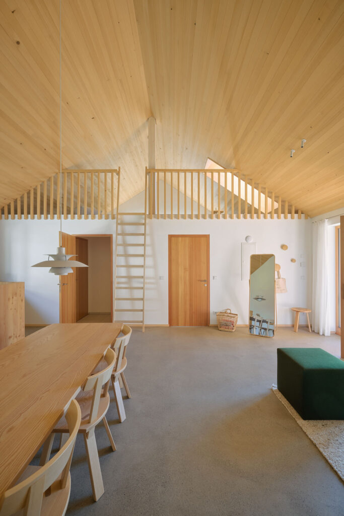 Roof apartment 1002 in the Aerli building with screed flooring and gallery under exposed roof trusses made of silver fir wood