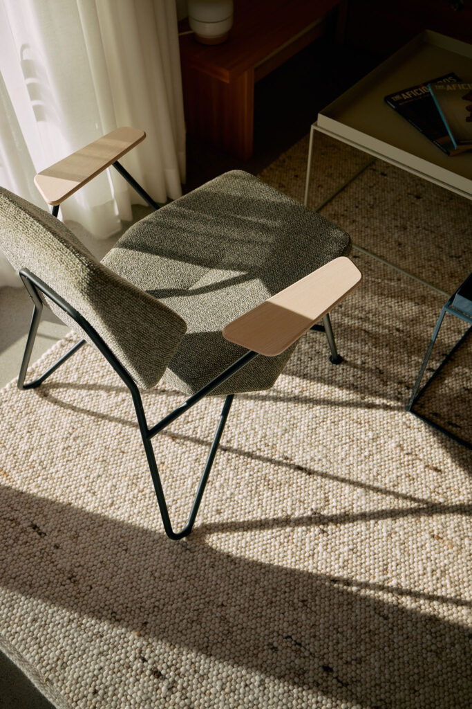 Grey designer chair by Prostoria stands on a hand-woven sheep's wool carpet in Haus Aerli.