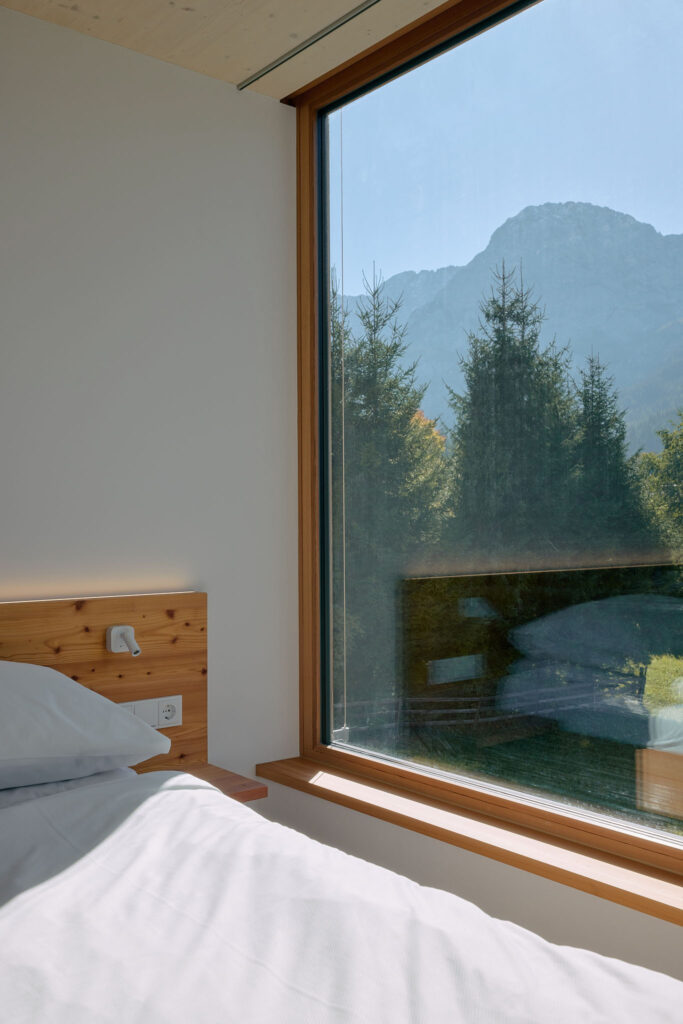 Atemberaubender Blick aus dem Panoramafenster im Apartment 1003 des Haus Aerli auf die Zugspitz-Region und dichte Nadelwälder.